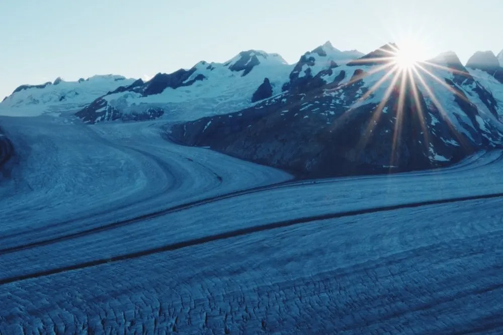 Sonnenaufgang über dem Konkordiaplatz, die Sonne bricht als Stern über den verschneiten Graten durch