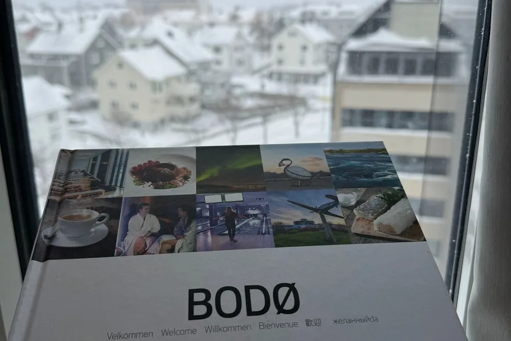 A Bodø brochure on the windowsill, the snow-covered town outside