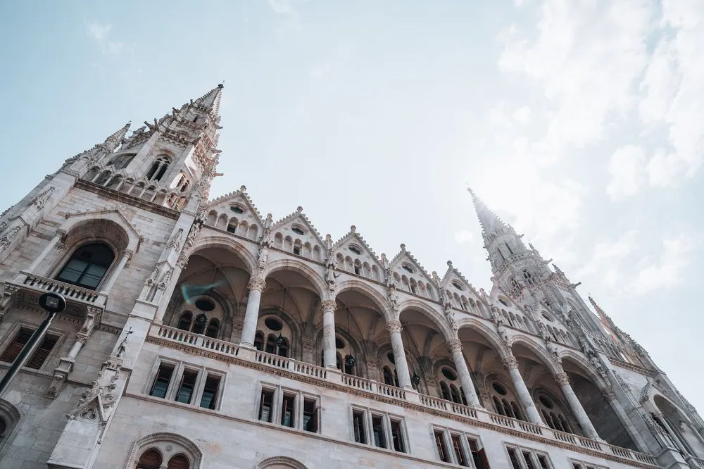Looking up along the façade of the Parliament building, with arcades and pointed turrets