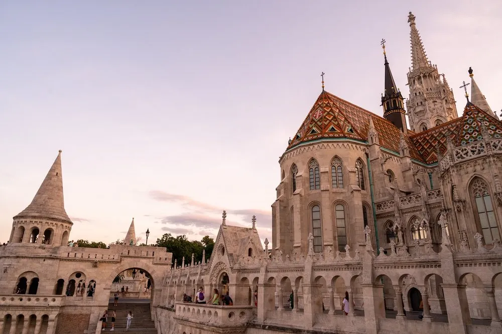 Die Arkaden der Fisherman's Bastion, dahinter das bunte Kirchendach und der Turm im Abendlicht