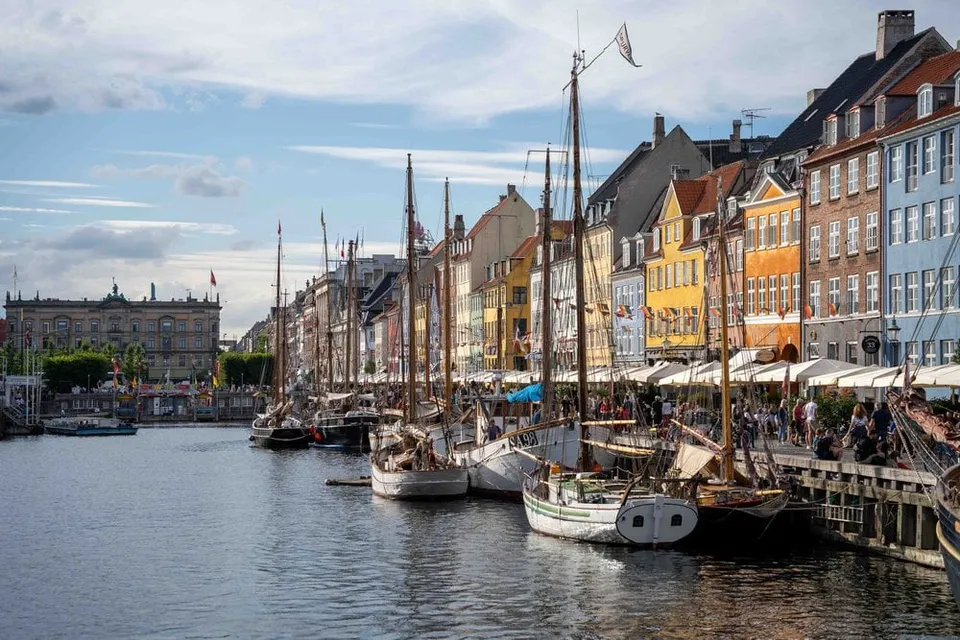 Die bunten Häuserfronten am Nyhavn in Kopenhagen mit Holzbooten im Kanal