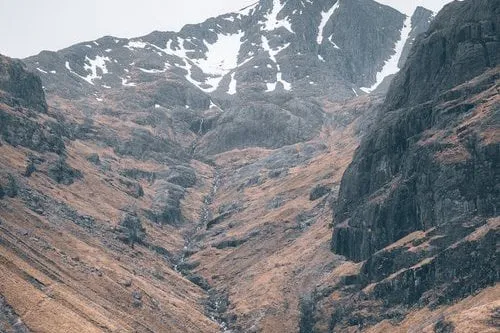 A narrow gorge in Glen Etive with a snow-flecked peak behind