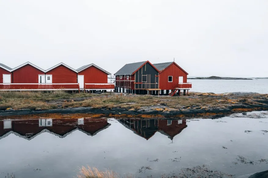 Red fishing cabins reflected on the coast at Bud