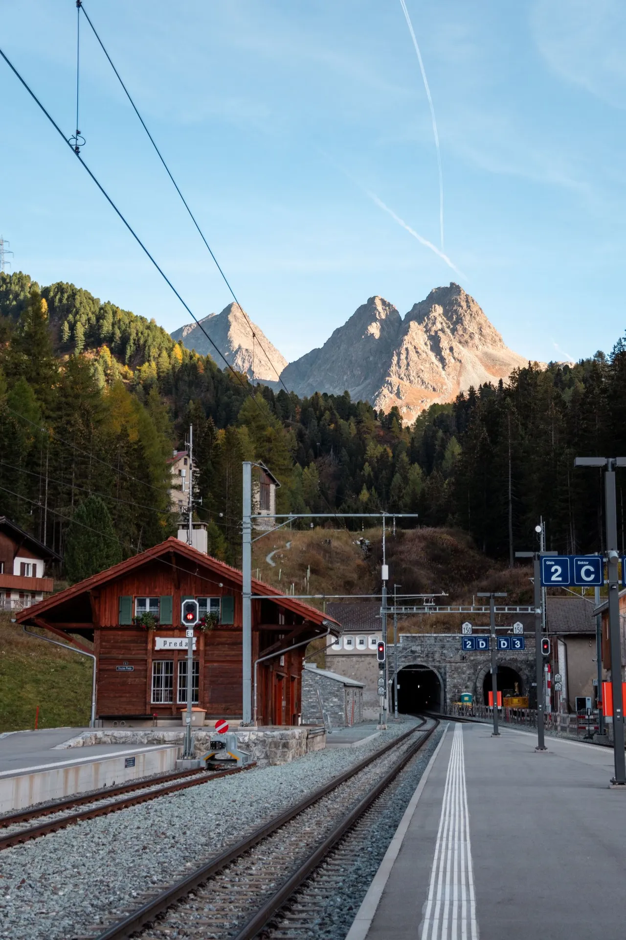 Der Bahnhof Preda mit dem Holzgebäude und den Portalen des Albulatunnels, darüber der Doppelgipfel des Dschimels