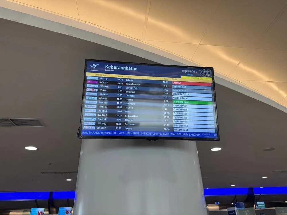 Departures board «Keberangkatan» in the airport terminal with flights to Jakarta, Denpasar, Bima and Labuan Bajo