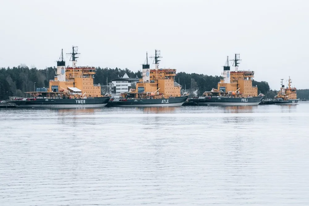Vier orange Eisbrecher liegen nebeneinander am Kai im Hafen von Luleå, auf den Rümpfen stehen Ymer, Atle und Frej