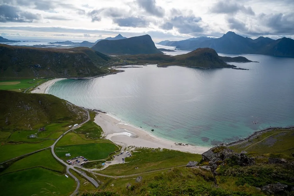 View from Mannen of Hauklandstranda with the road and car park, sea and mountains behind