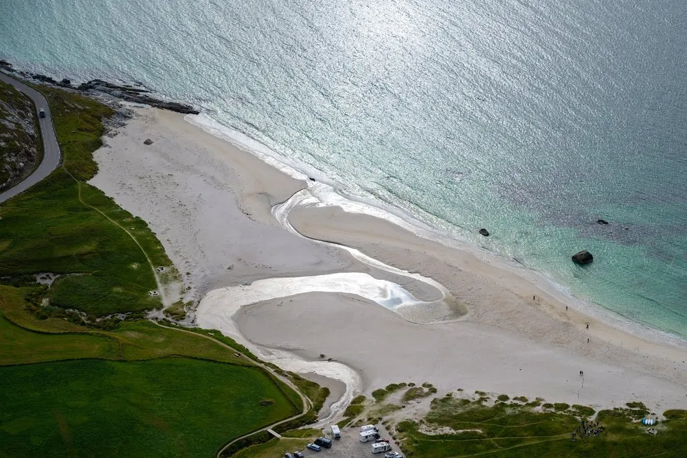 From up high: sandbanks and tidal channels at Hauklandstranda, vehicles on the car park below