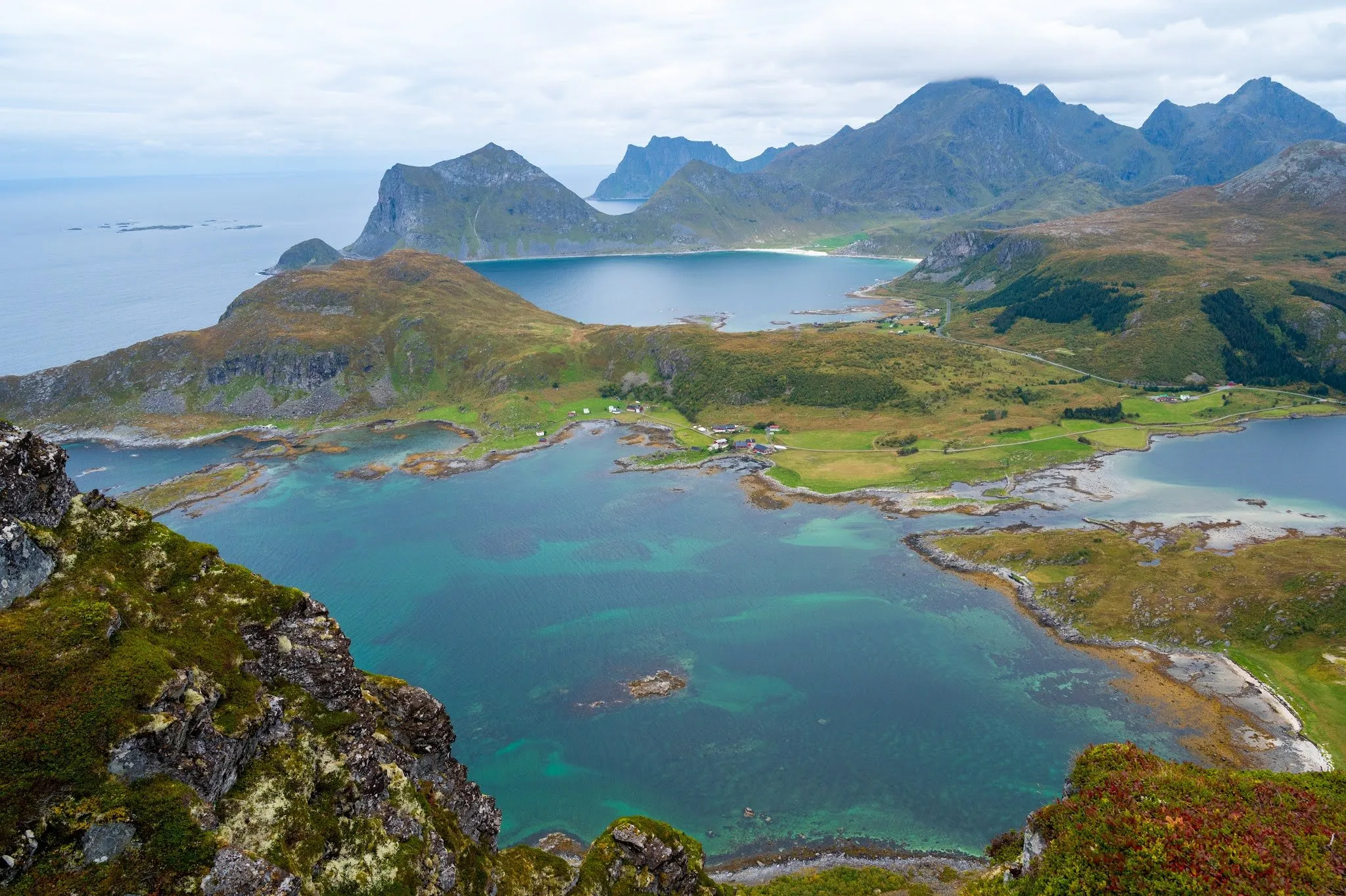 Turquoise water, green peninsulas and mountain ranges, seen from a high rock