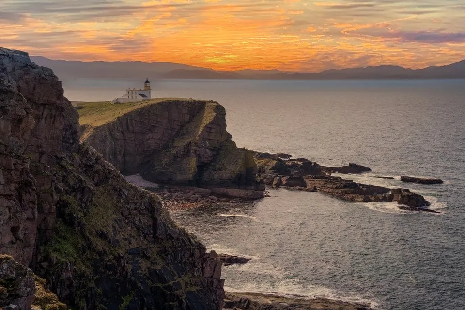 Stoer Lighthouse on its cliff at sunset