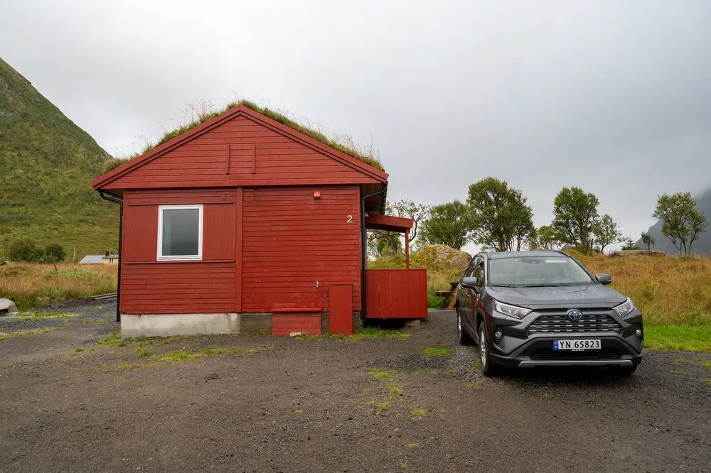 Little red house with a grass roof on the campsite in Rystad, our grey Toyota RAV4 in front of it