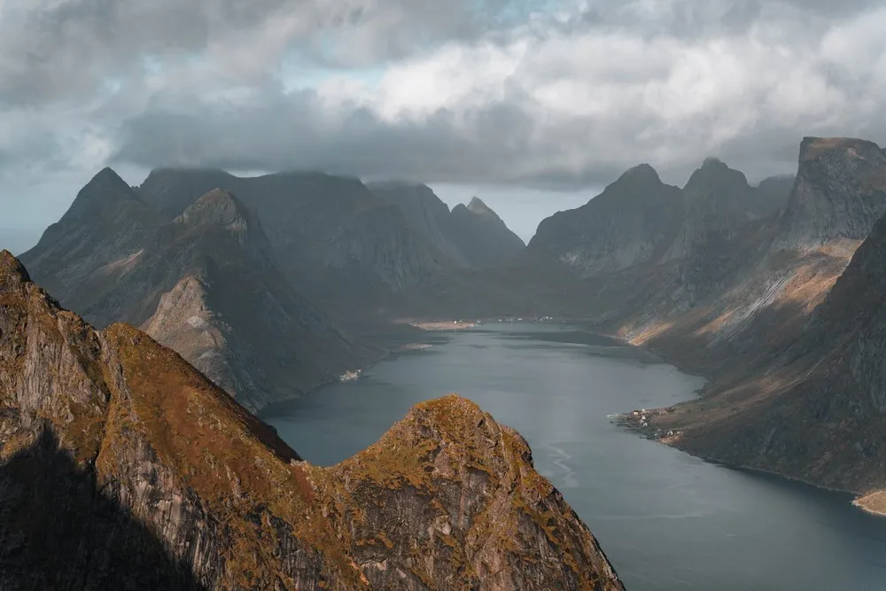 Vom Reinebringen auf einen langen Fjord zwischen dunklen Bergen, darüber Wolken