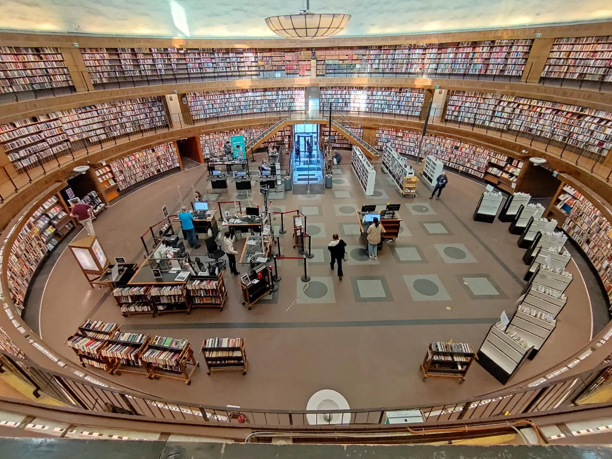 View from above into the round hall of the city library, bookshelves along the walls and lending desks in the middle