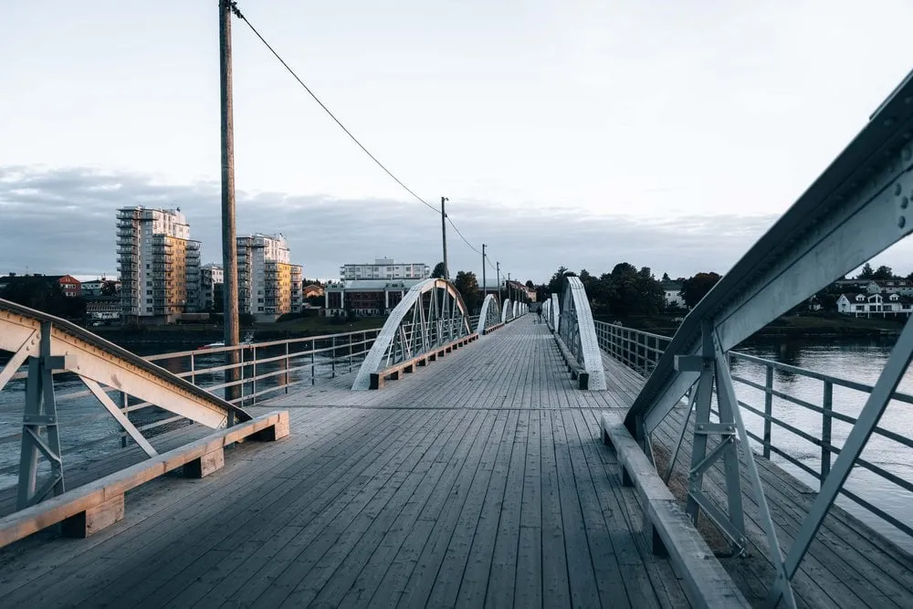 Eine Fussgängerbrücke führt über den Fluss nach Umeå hinein