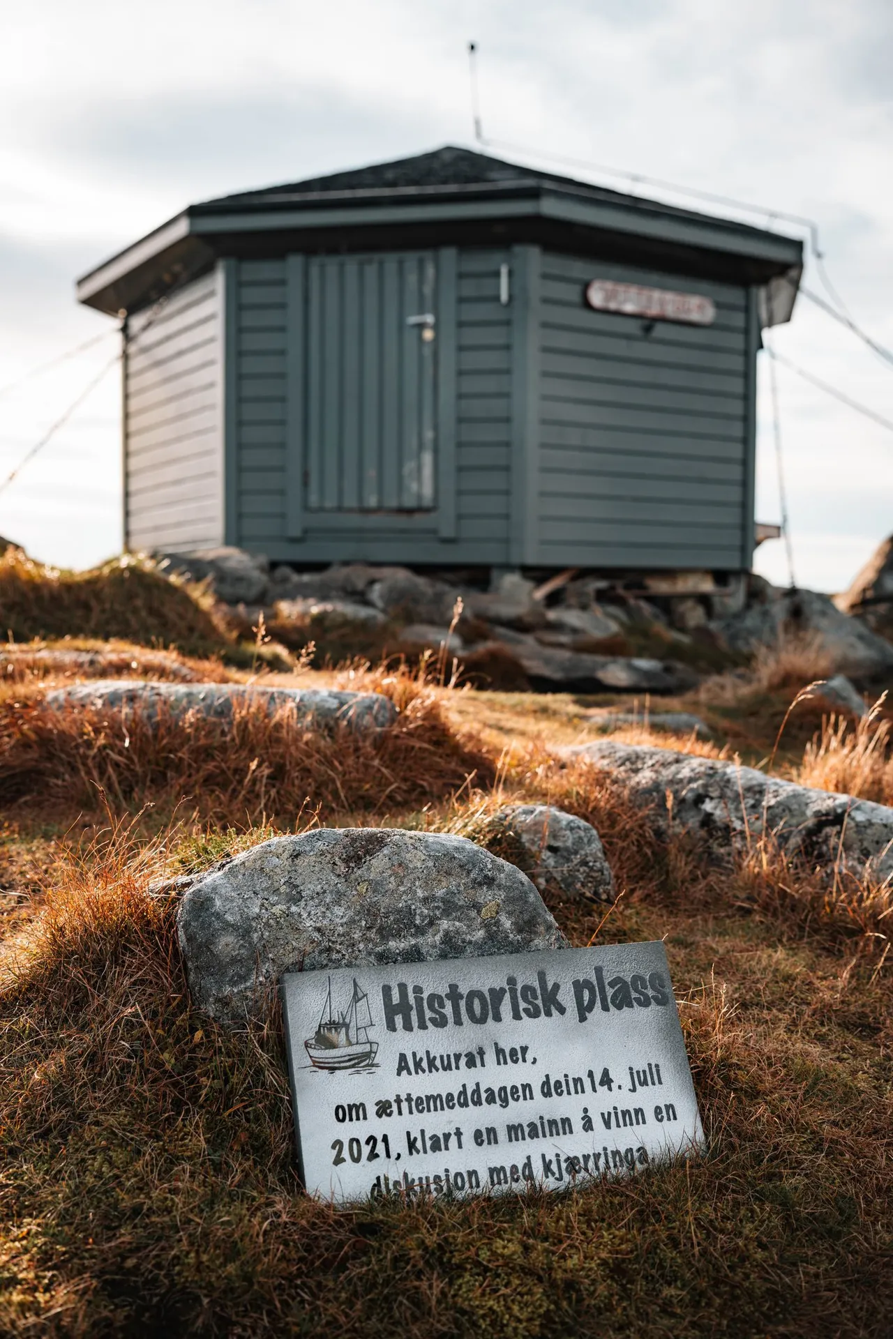 Die Hütte Vettenbua, davor ein Stein mit der Tafel «Historisk plass»