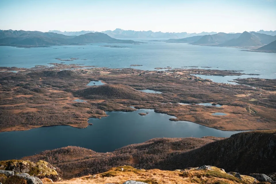 Seen und Moore auf der Hochebene unter dem Vetten, dahinter das Meer und am Horizont die Lofoten